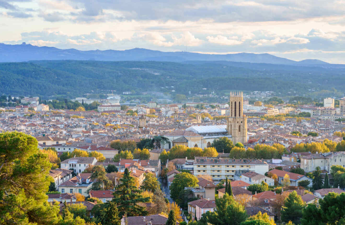 Sunset view of Aix-en-Provence, France, with the Saint-Sauveur Cathedral towering over the city and the rolling Provence hills in the backdrop
