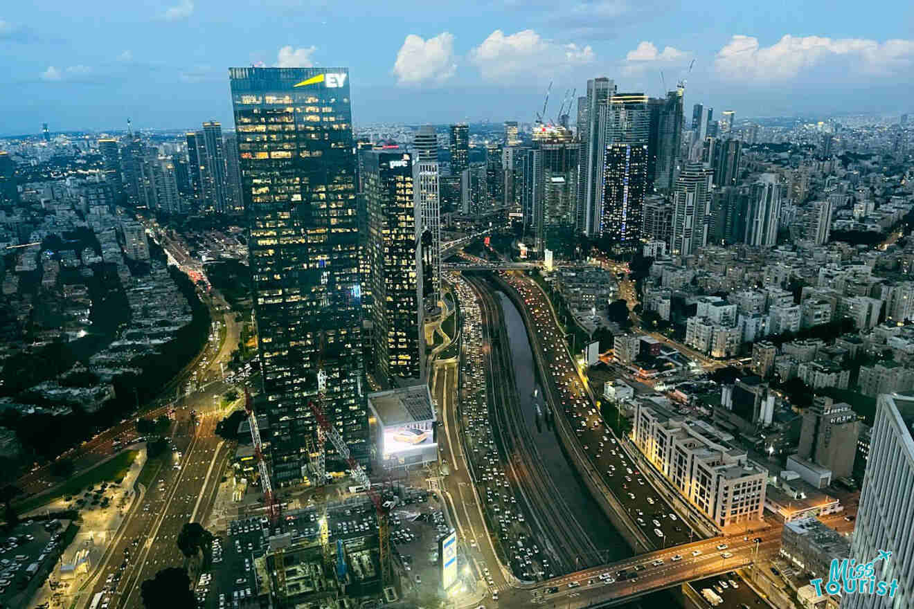 Aerial view of Tel Aviv at night from the Azrieli Observatory, showing the city's bright lights and busy traffic patterns