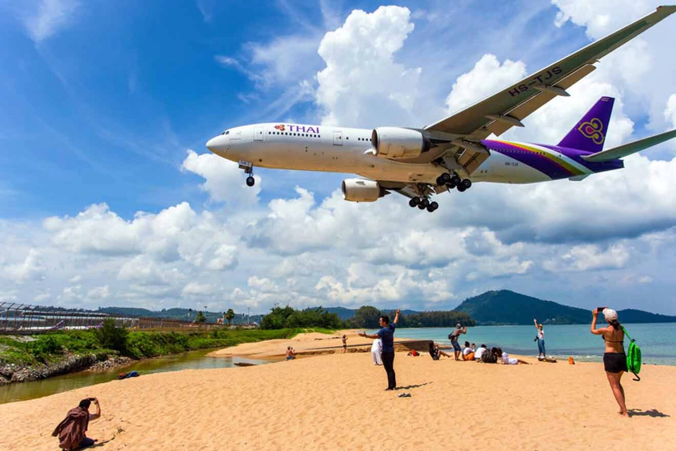 Spectacular scene at Mai Khao Beach with a Thai Airways plane flying low over beachgoers against a backdrop of clear blue skies, providing a unique and thrilling experience.