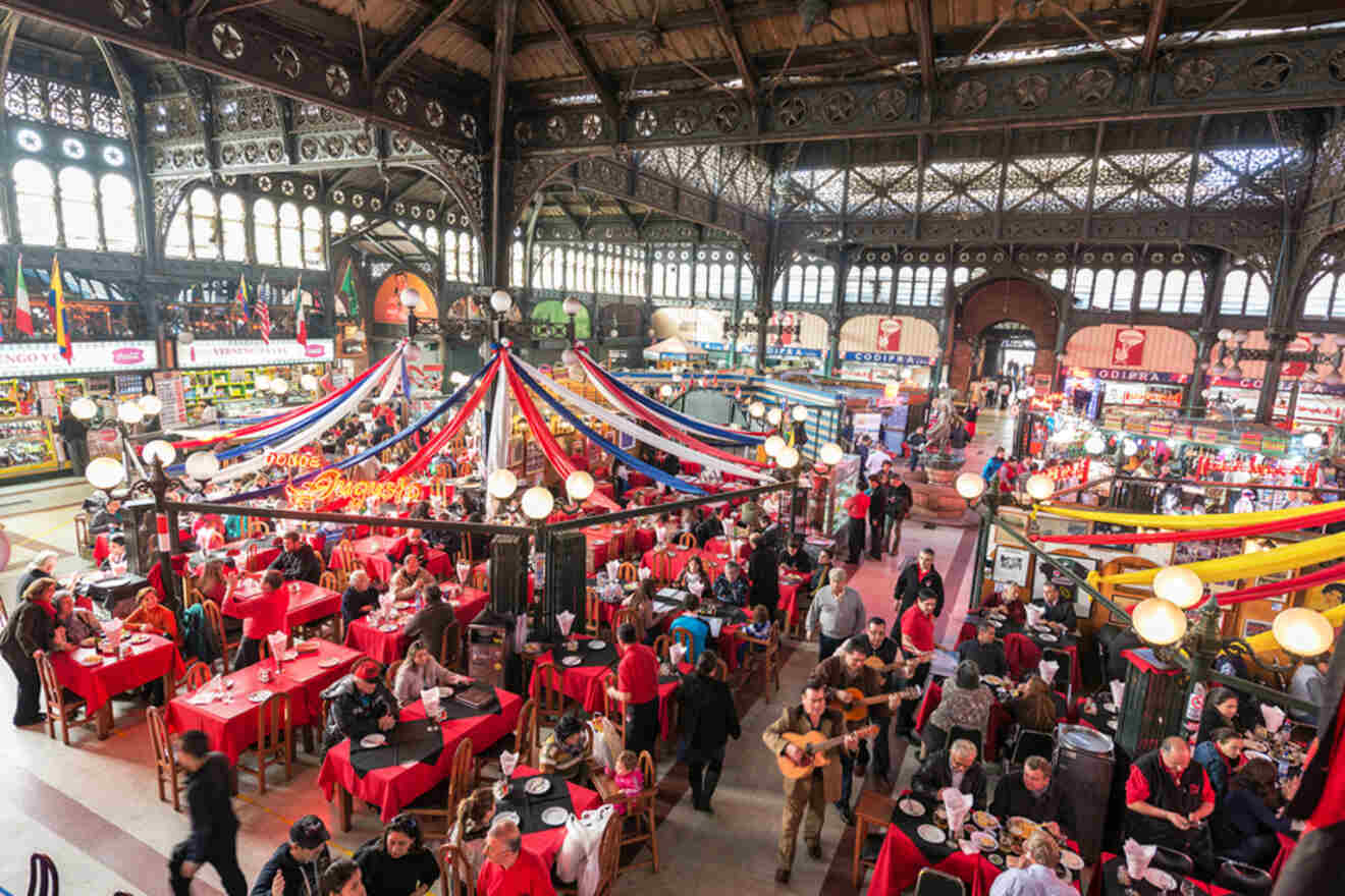 Vibrant atmosphere inside Santiago’s Central Market, with festive decorations, dining patrons, and live music performance