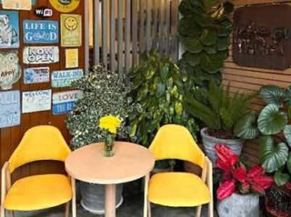 Charming hotel sitting area with bright yellow chairs and a collection of cheerful signs, creating a lively and welcoming ambiance for guests.