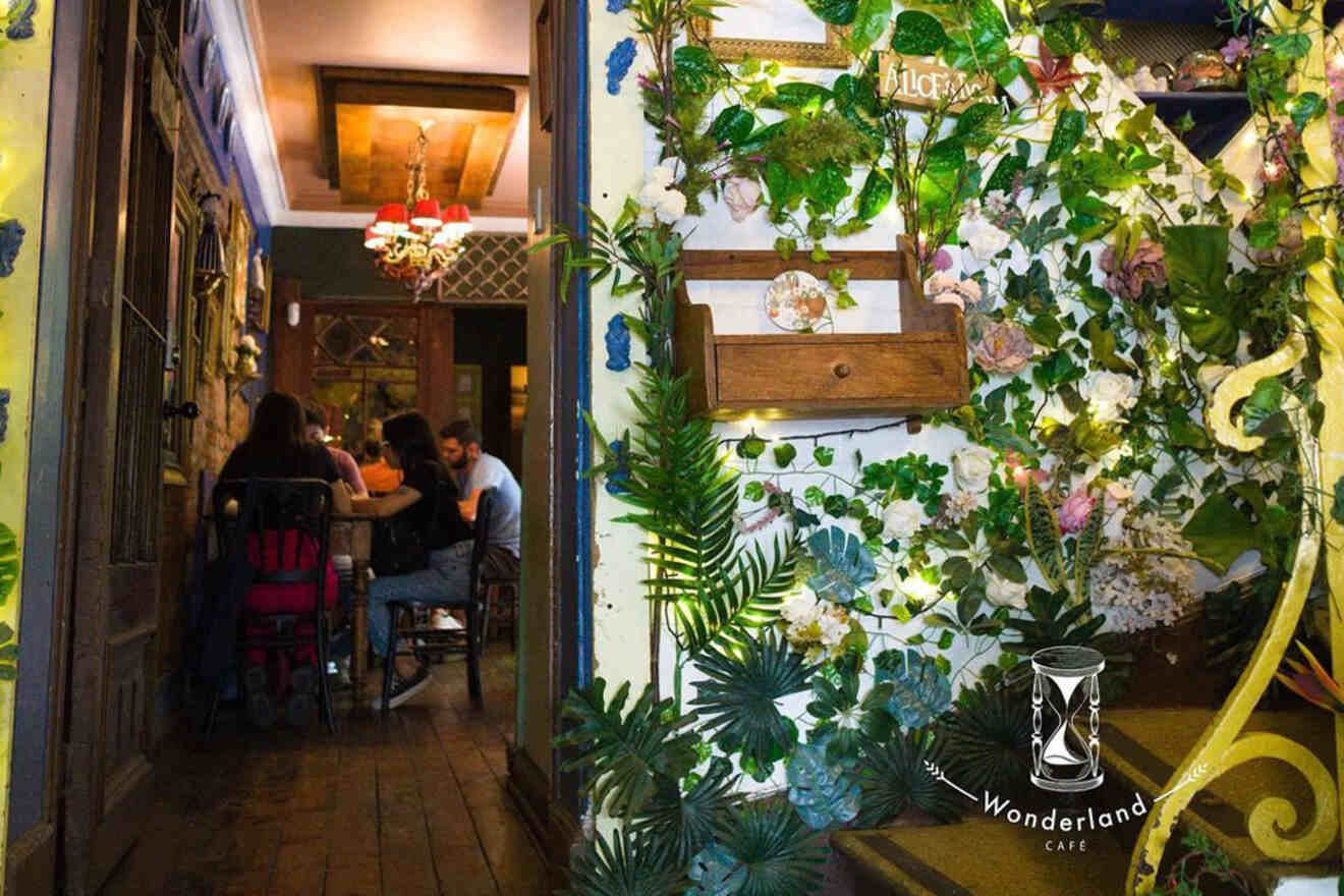Intimate ambiance at Santiago’s Wonderland Café, with vintage décor, floral wallpaper, and patrons engaged in conversation