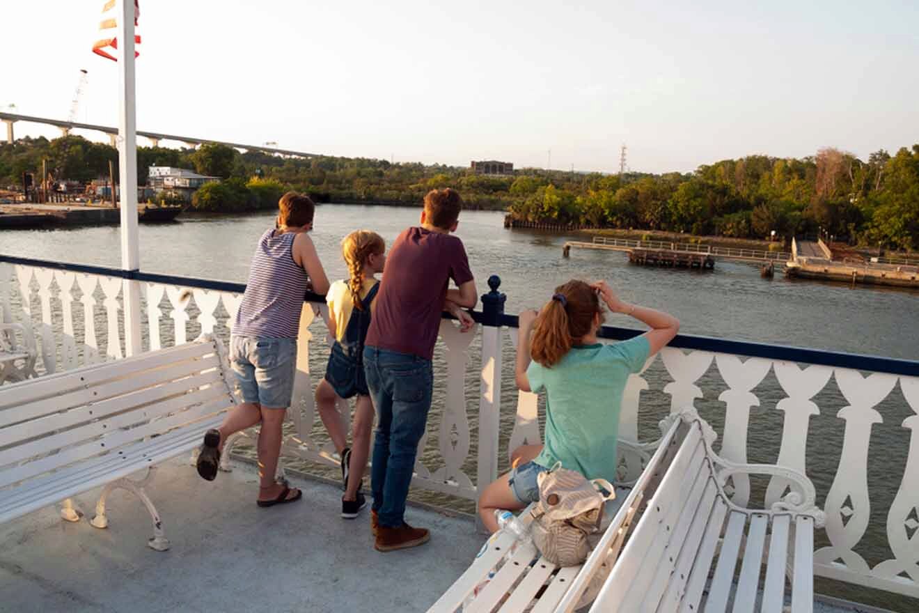 A group of people enjoying the river view from the deck of a ferry, a typical sightseeing activity in Savannah for families.