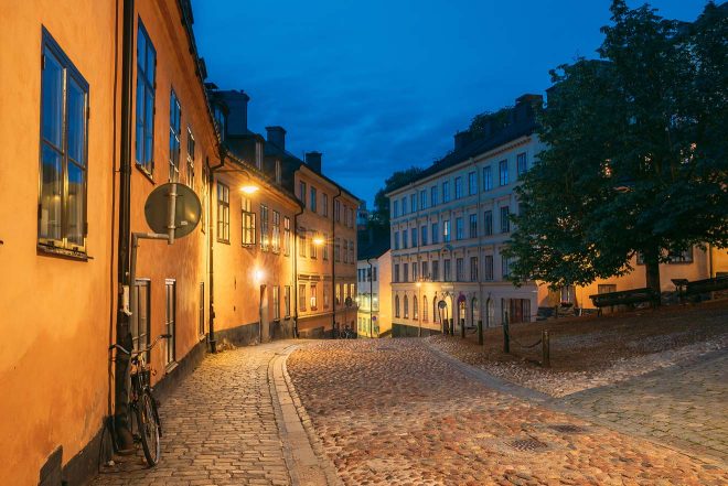 Cobblestone street in Stockholm's old town during evening with warm lighting and buildings




