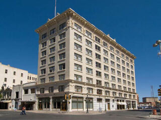 Exterior view of the historic Hotel Gibbs building in daylight with clear blue skies.