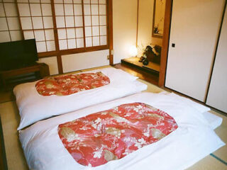 Twin futon beds with red floral bedding in a Japanese-style room