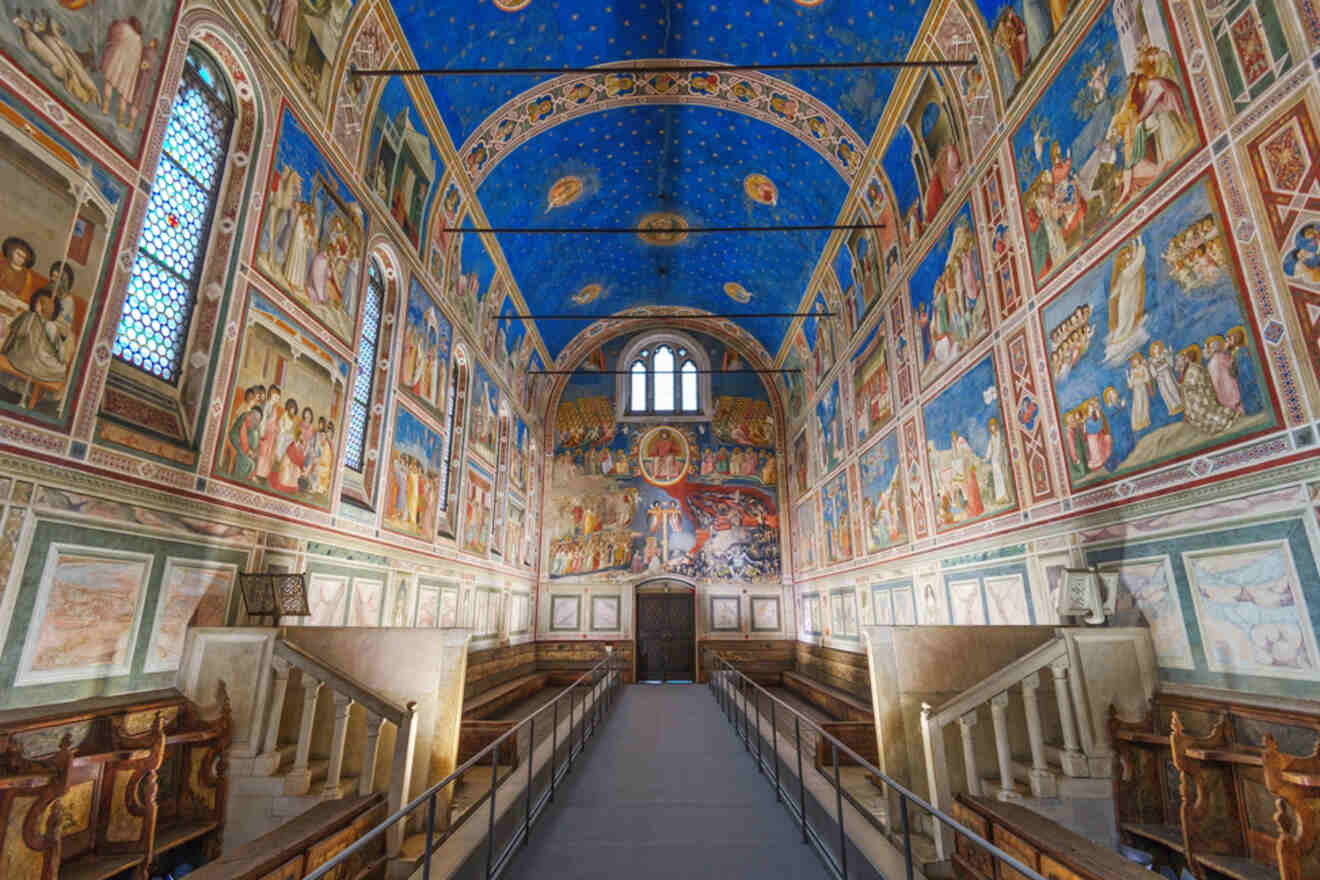 Interior of Scrovegni Chapel in Padua, showcasing the stunning frescoes by Giotto on blue starry ceiling and walls