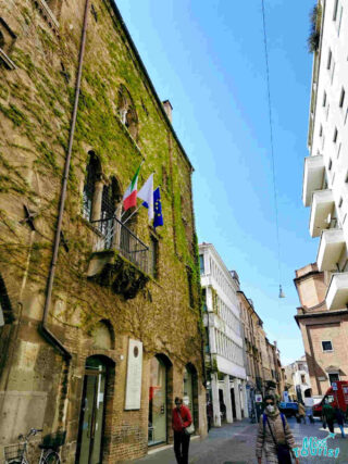 The moss-covered walls of the Padua Jewish Ghetto, showing a contrast between the historical building and modern streets
