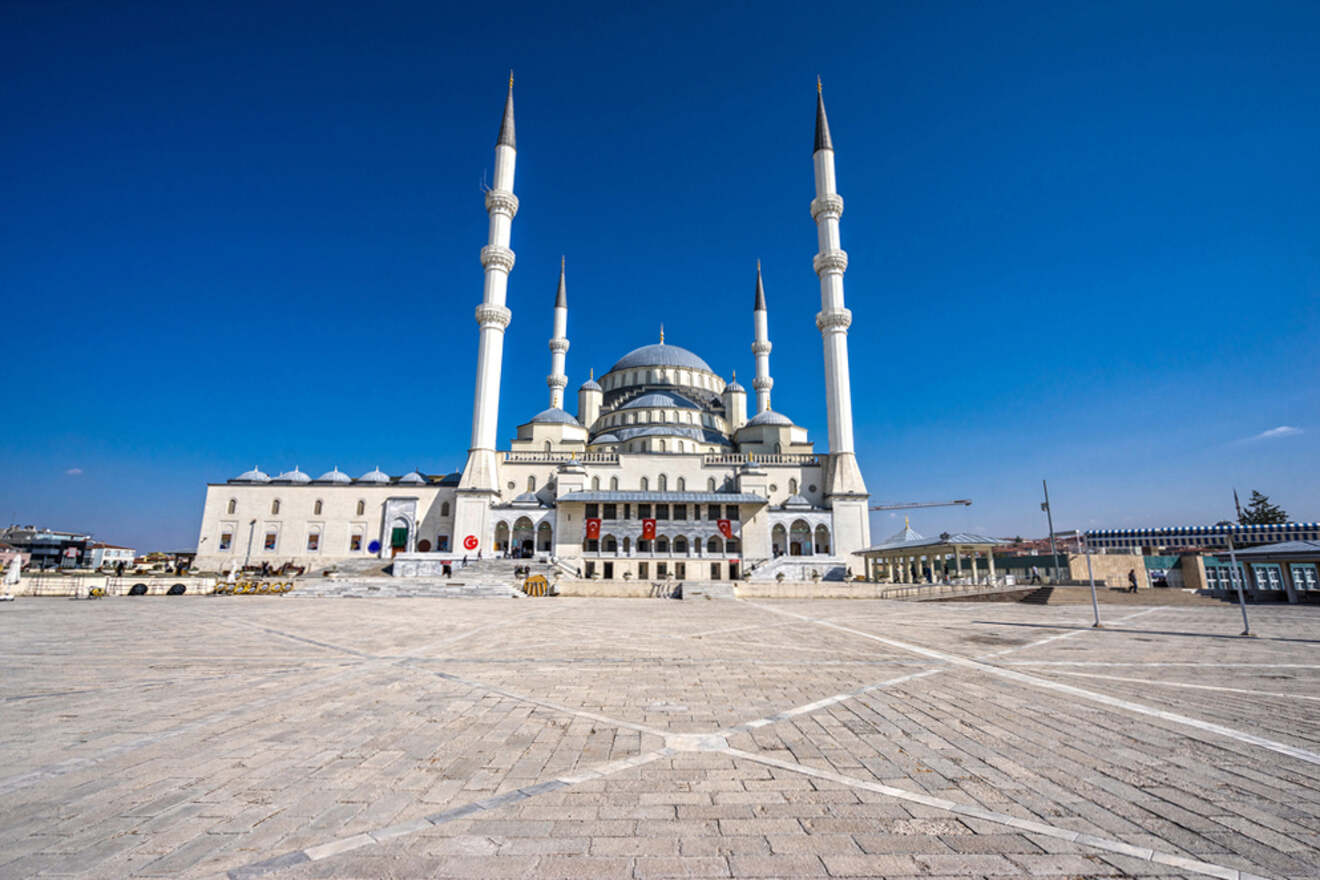 The grand Kocatepe Mosque in Ankara under a clear blue sky, showcasing its impressive architecture with four slender minarets and cascading domes, a landmark of religious and cultural significance.
