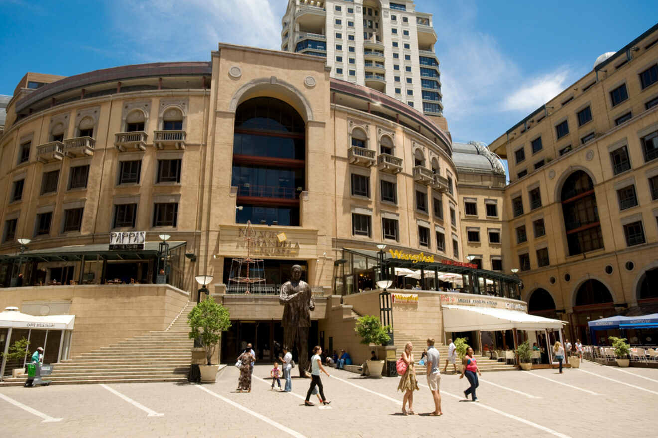 Nelson Mandela Square in Sandton bustling with activity, showcasing a statue of Nelson Mandela, surrounded by outdoor restaurants and a backdrop of grand architecture