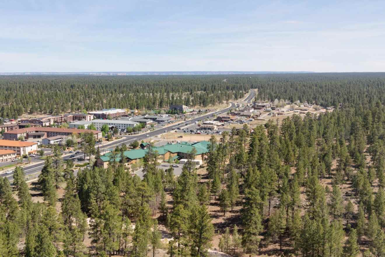 Aerial view of Tusayan, a small town with buildings surrounded by dense pine forests, located near the main entrance of the Grand Canyon.