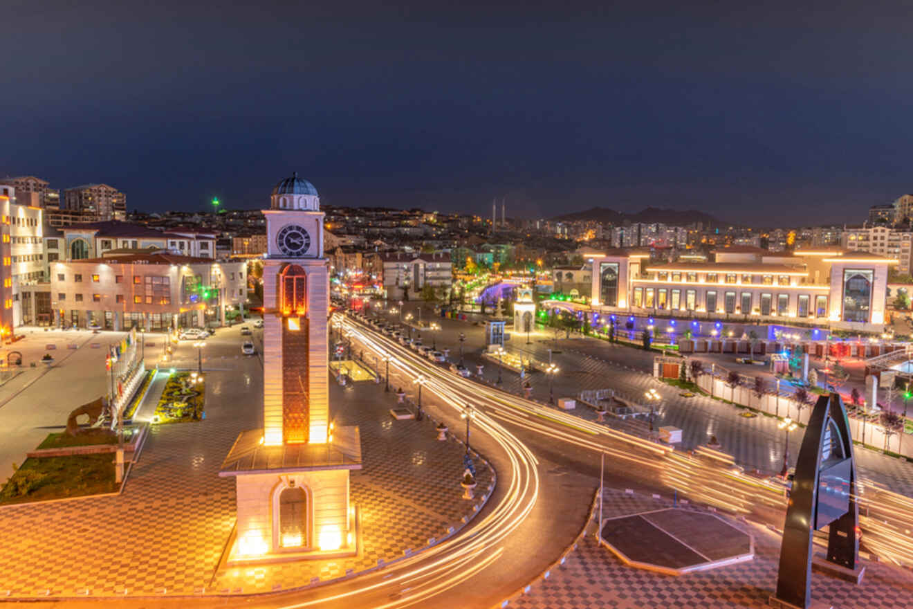 A panoramic view of Ankara cityscape at dusk, featuring a clock tower illuminated in the foreground.