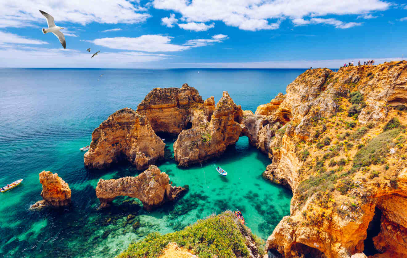 Breathtaking view of the Ponta da Piedade cliffs with their rugged natural arches overlooking turquoise waters, as seagulls glide in the bright blue sky