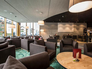 Hotel lounge with dark furniture and contemporary lighting.