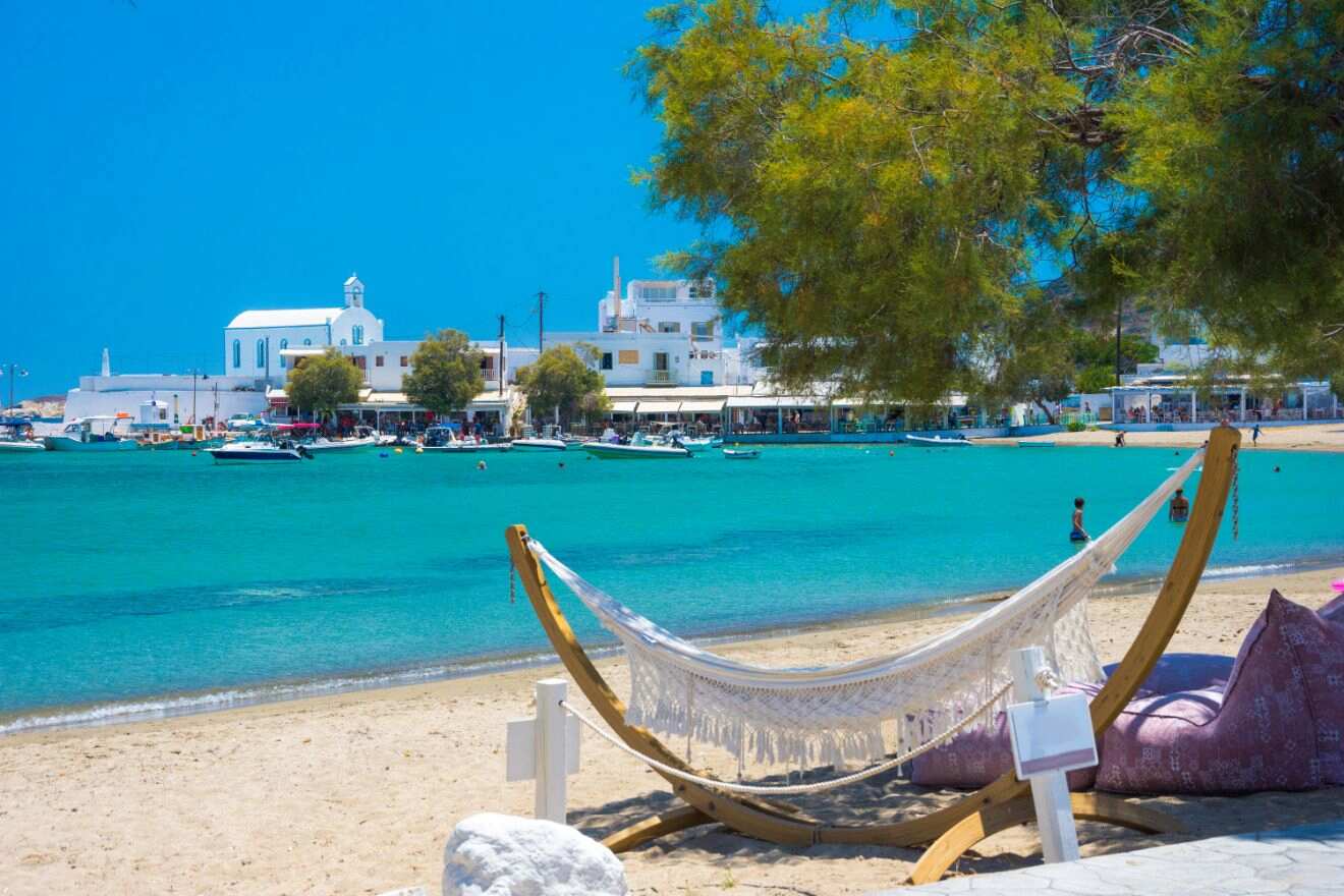 Relaxing beach scene with a hammock overlooking a picturesque Greek church and azure waters