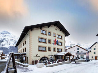 Albana Hotel facade in winter, traditional architecture with mountain backdrop