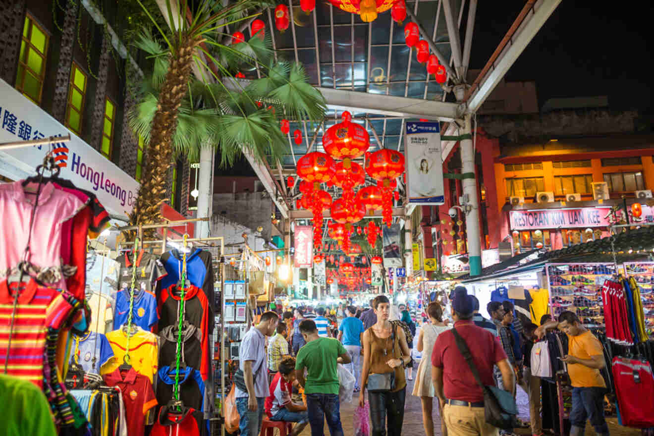 A bustling night market with a group of people strolling through, exploring various stalls and enjoying the vibrant atmosphere.