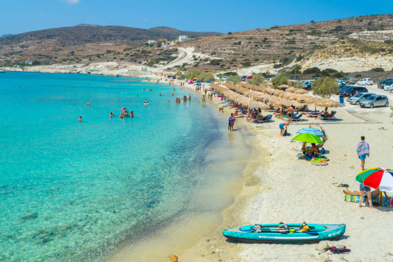 Bustling Greek beach with clear turquoise waters, beachgoers enjoying the sun, and thatched umbrellas lining the shore