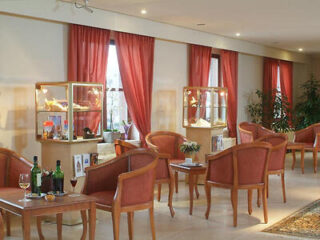 Elegant hotel lounge with red curtains and salmon pink armchairs