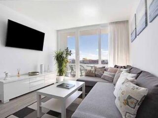Bright living space with a gray sofa and cityscape view.