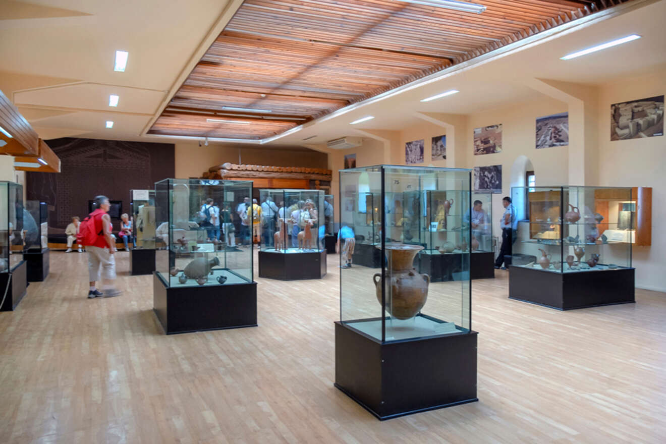 Visitors inside the Museum of Anatolian Civilizations in Ankara viewing an extensive collection of ancient pottery and artifacts displayed in glass cases