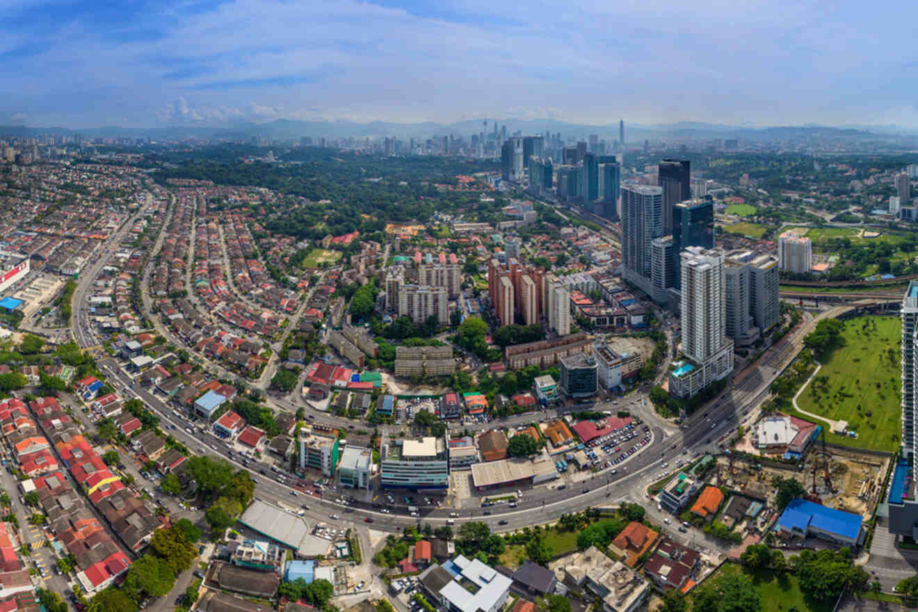 Aerial view of a bustling cityscape with skyscrapers, urban roads, and residential areas on a clear day.