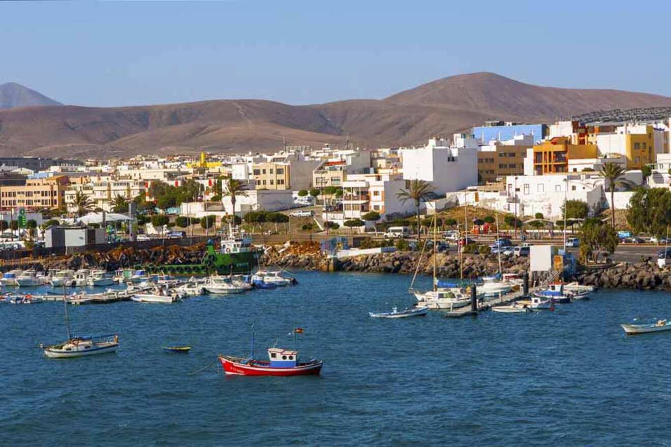Coastal town of Puerto del Rosario in Fuerteventura, showcasing a harbor with boats, white houses, and distant mountains