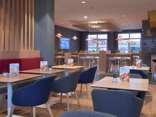 Casual dining area in Holiday Inn Express with a mix of booth and bar seating, modern decor, and warm lighting