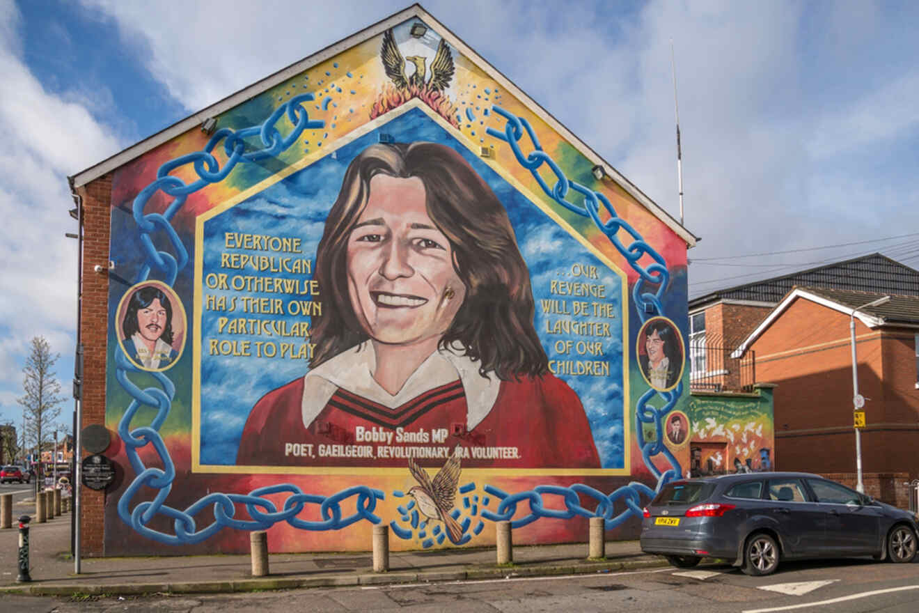 Vibrant political mural in Belfast depicting Bobby Sands, surrounded by symbolic chains and phoenix imagery, reflecting the city's complex history and culture