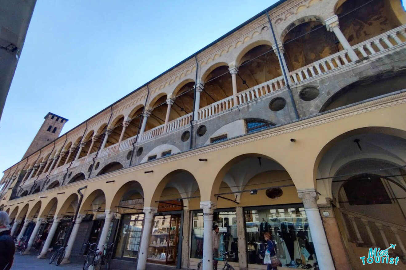 The historical Palazzo della Ragione in Padua, featuring a long façade with arched walkways and a tower in the background