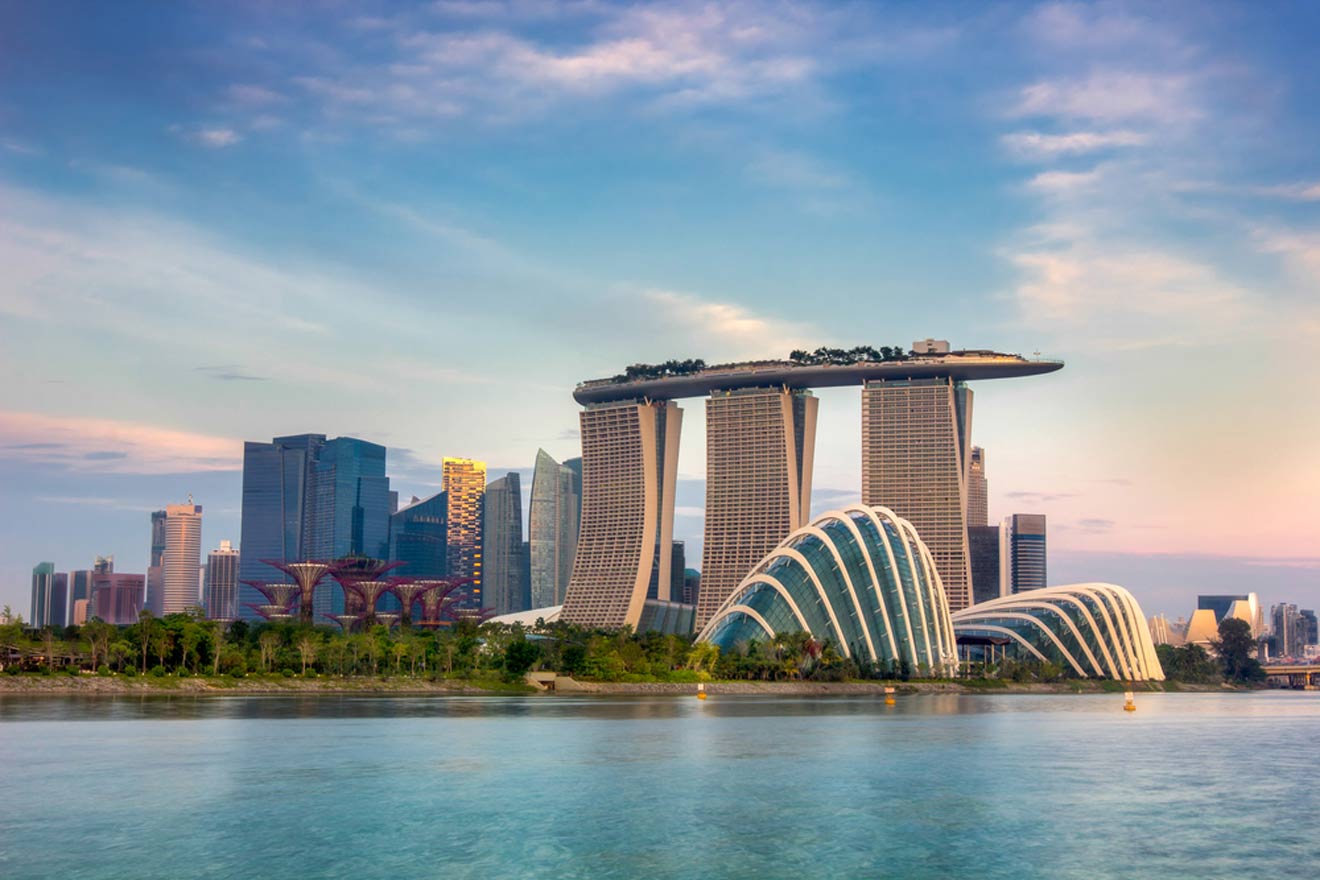 Singapore skyline featuring marina bay sands and gardens by the bay at dusk.