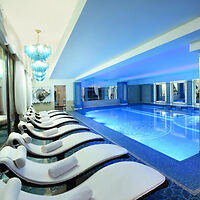 An elegant indoor swimming pool in a luxury hotel with blue mood lighting