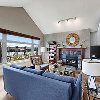 Stylish living room interior with a fireplace and a view of the waterfront patio
