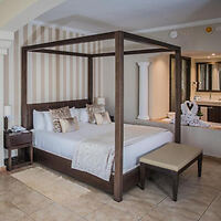 An elegantly appointed hotel bedroom with a four-poster bed and plush linens