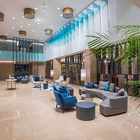 Elegant hotel lobby with blue and gray seating, tall ceilings, and contemporary design elements