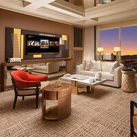 Luxurious living room with plush seating, a large flat-screen TV, and a sunset view