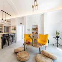 Modern and cozy common area with yellow armchairs and a sleek bar counter
