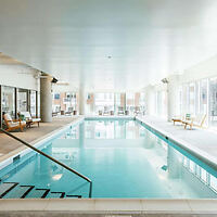 Elegant indoor swimming pool with clear blue water, surrounded by lounging areas and large windows