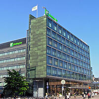 "Exterior view of the Holiday Inn hotel, showcasing its modern facade with glass windows