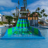 Colorful and inviting resort pool featuring a fun water slide with a pirate-themed play area