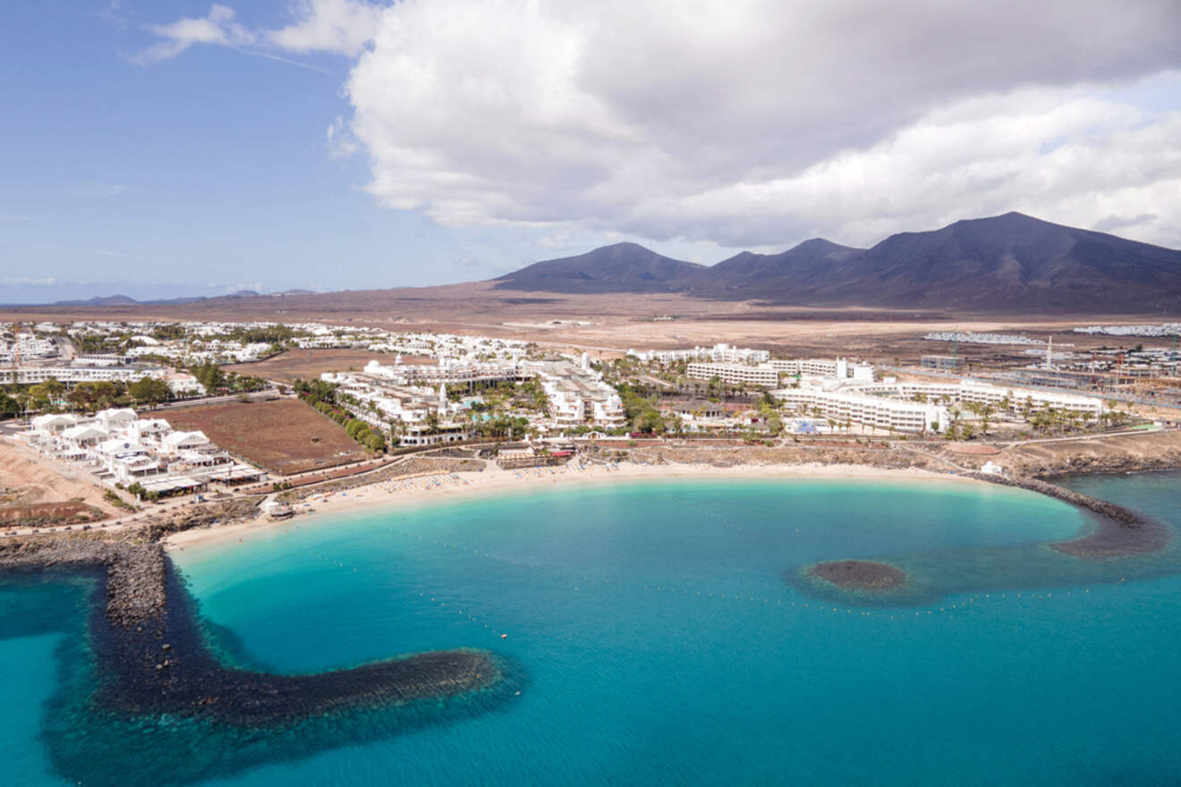 Aerial view of Playa Blanca, Lanzarote, capturing the inviting turquoise waters of the beachfront and the sprawling layout of the resort town
