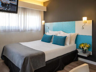 Stylishly furnished bedroom with a large bed and aqua-colored headboard