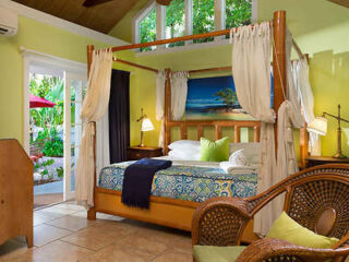 Tropical-themed bedroom with a four-poster bed, vibrant blue and yellow bedding