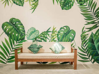 Chic lounge area with tropical monstera leaf patterns and wooden furniture in Krabi