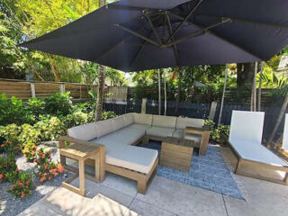 Outdoor patio with a large U-shaped lounge area under a big umbrella