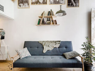 A minimalist Scandinavian-style living area with a sleek navy blue sofa