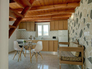 Kitchen and dining area, with wooden ceiling beams and natural stone accents