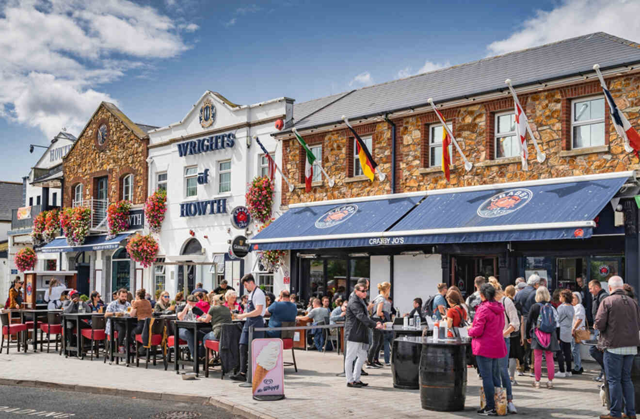 A popular Dublin pub with patrons enjoying outdoor seating, decorated with flowering plants and international flags, exemplifying the city's vibrant pub culture.