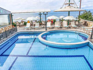 Second image: "Hotel pool with a jacuzzi and sea views, lined with loungers and parasols