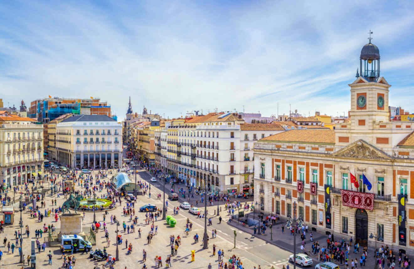 High-angle view of Puerta del Sol, a busy central square in Madrid, with buildings, pedestrians, and the famous Tio Pepe sign